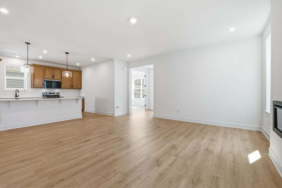 Great room with electric fireplace open to the kitchen.(Stock Photos of similar model)