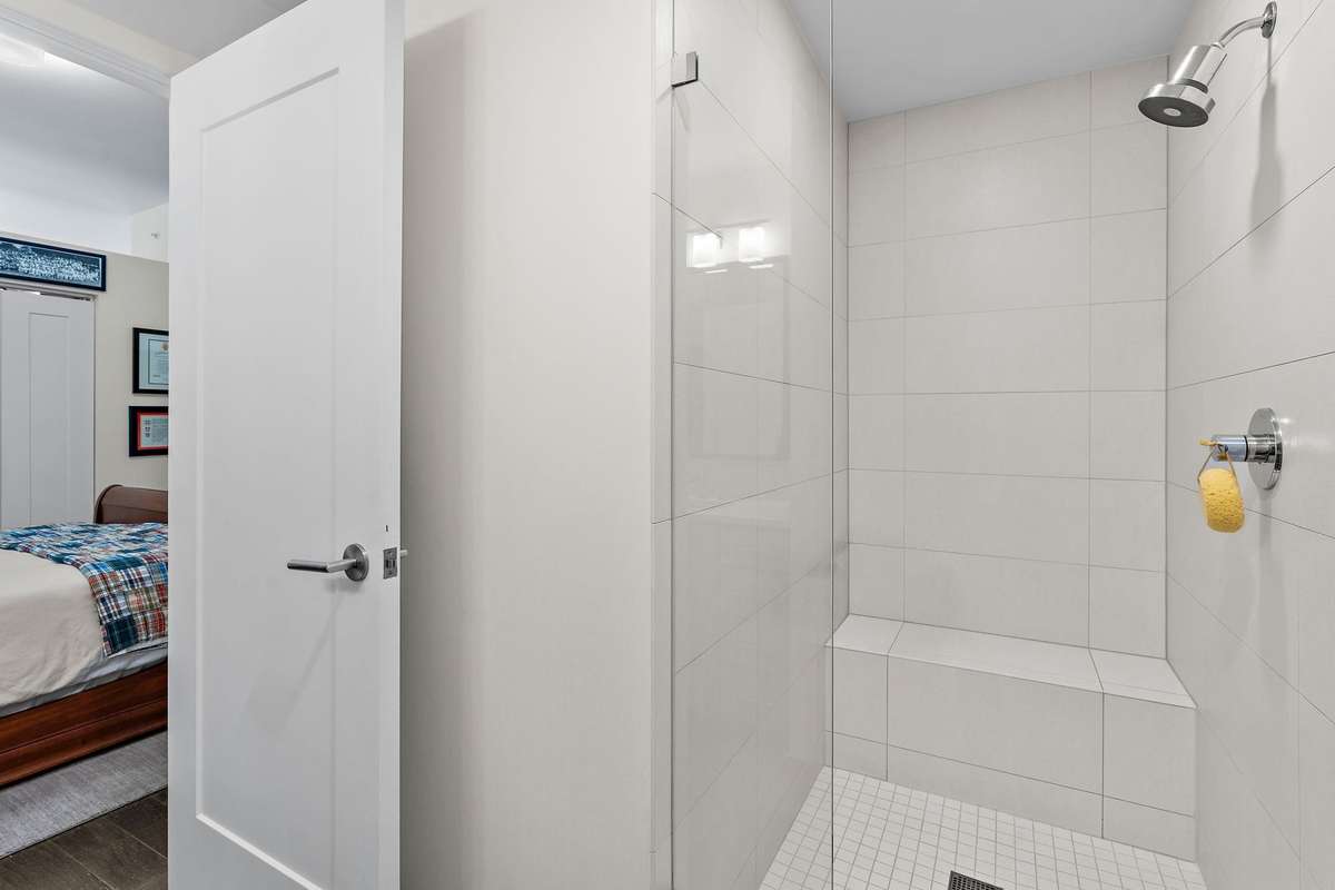 Glass-front walk-in tile shower with built-in bench seat