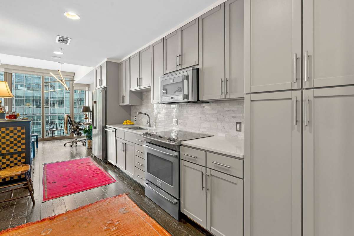 Modern open kitchen leads into the dining + living