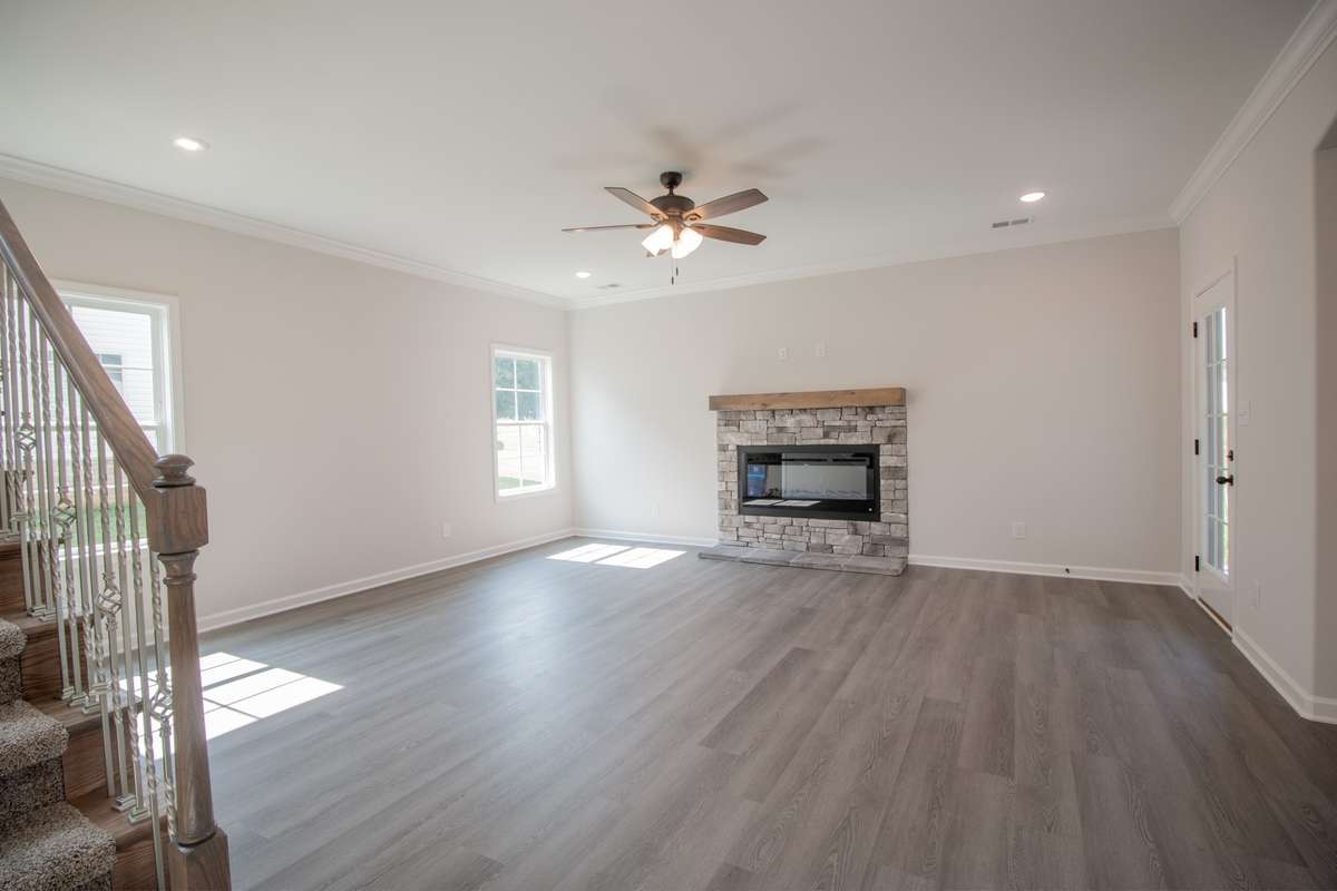 EXAMPLE>>> Large Living Room with a Stone Fireplace, Floating Wood Mantle, Crown Molding, Tons of Natural Lighting and Access to the Large Covered Patio!