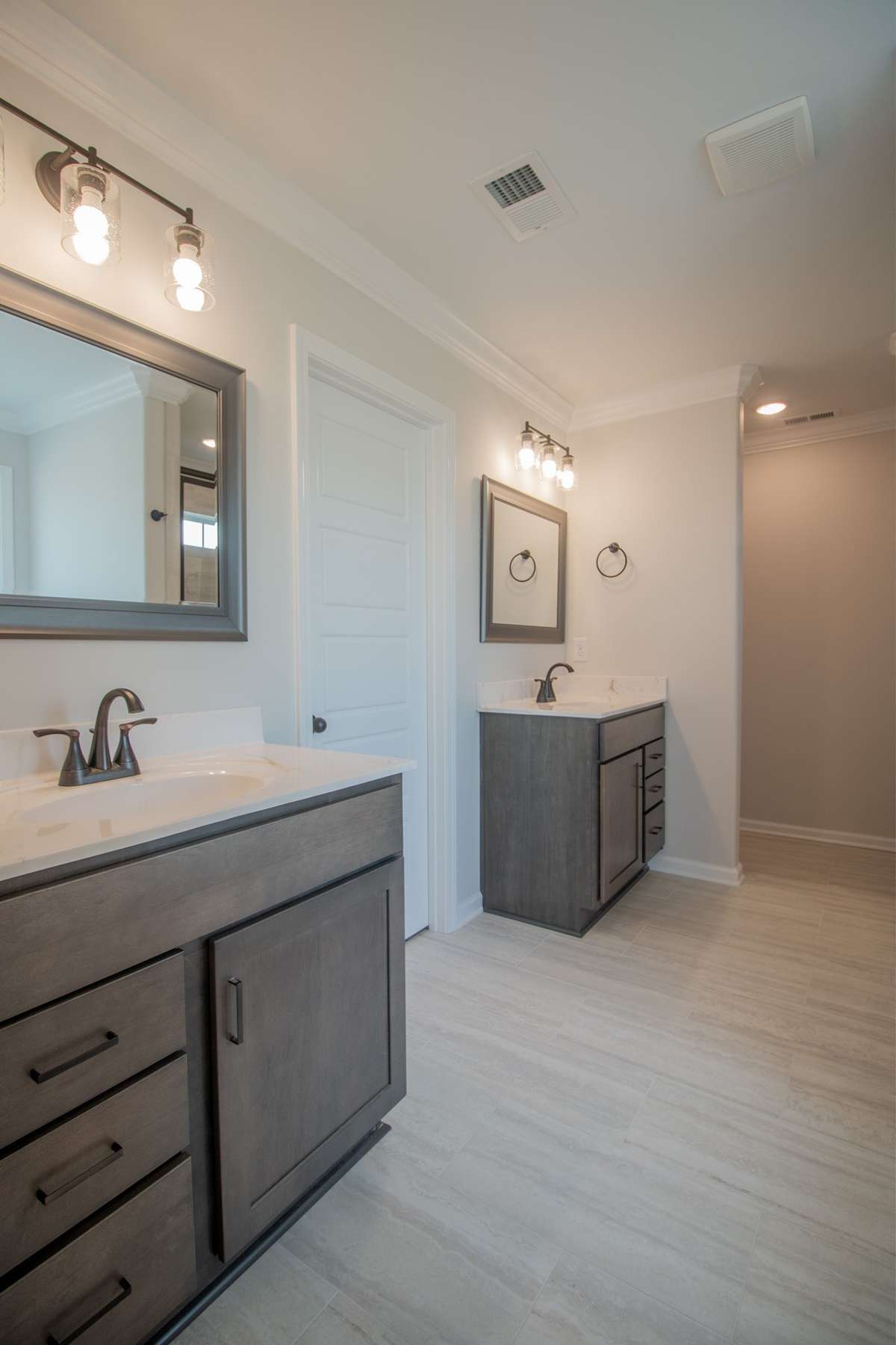 EXAMPLE>>> Primary Bathroom with Tile Flooring, Crown Molding, Separate Vanities, Tile Shower, Built-in Wall Shelving, and a Walk-in Closet!