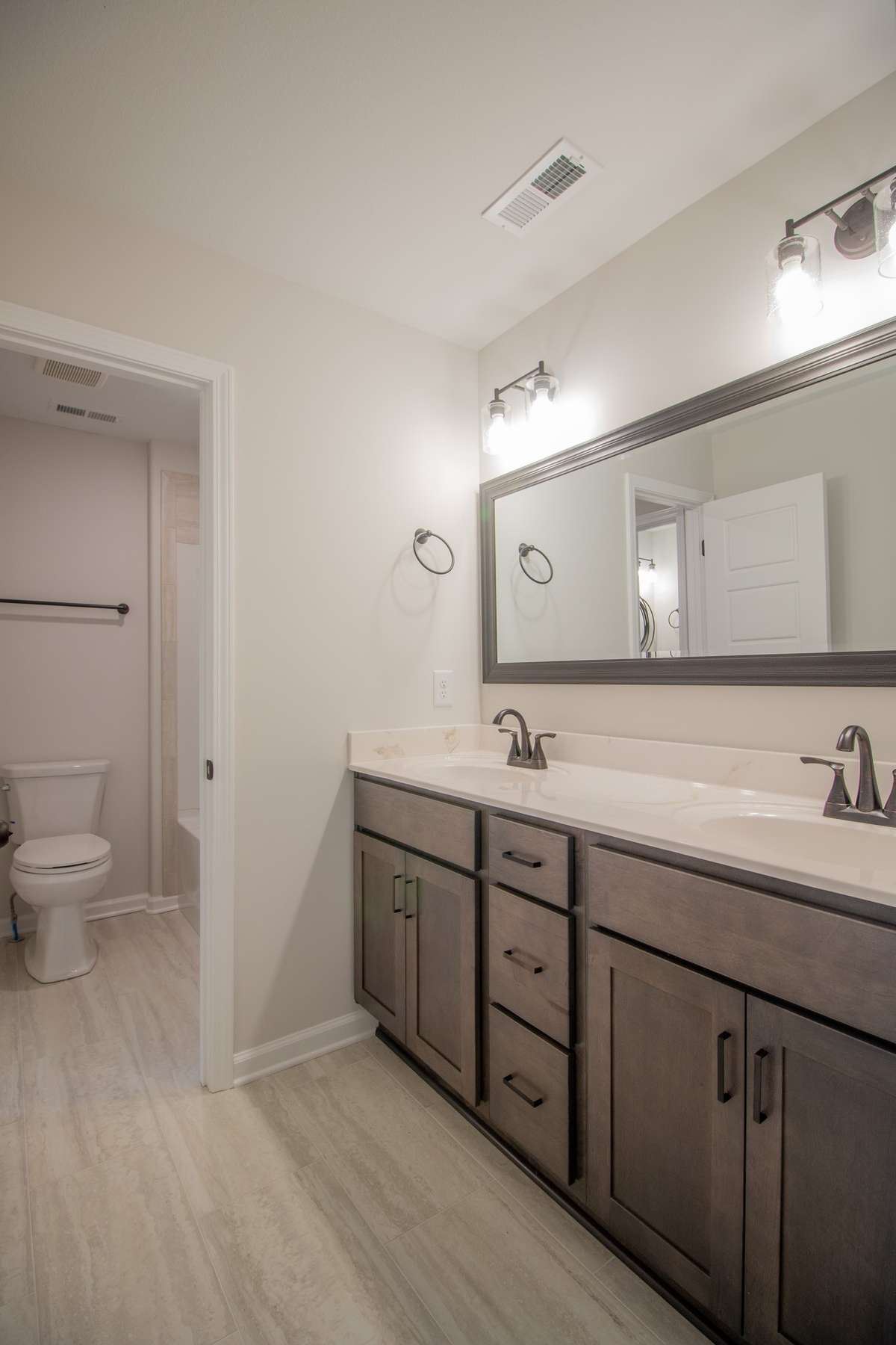 EXAMPLE>>> Guest Bathroom with a Double Vanity, Large Framed Mirror and a Private Shower/Toilet Room!