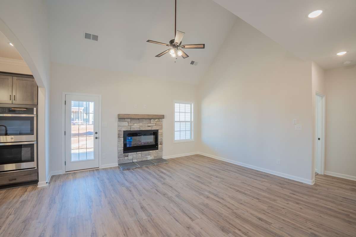 EXAMPLE>>> Large Vaulted Living Room with a Natural Gas Stone Fireplace, Floating Wood Mantle, Recessed Lighting, and Access to the Large Covered Patio!