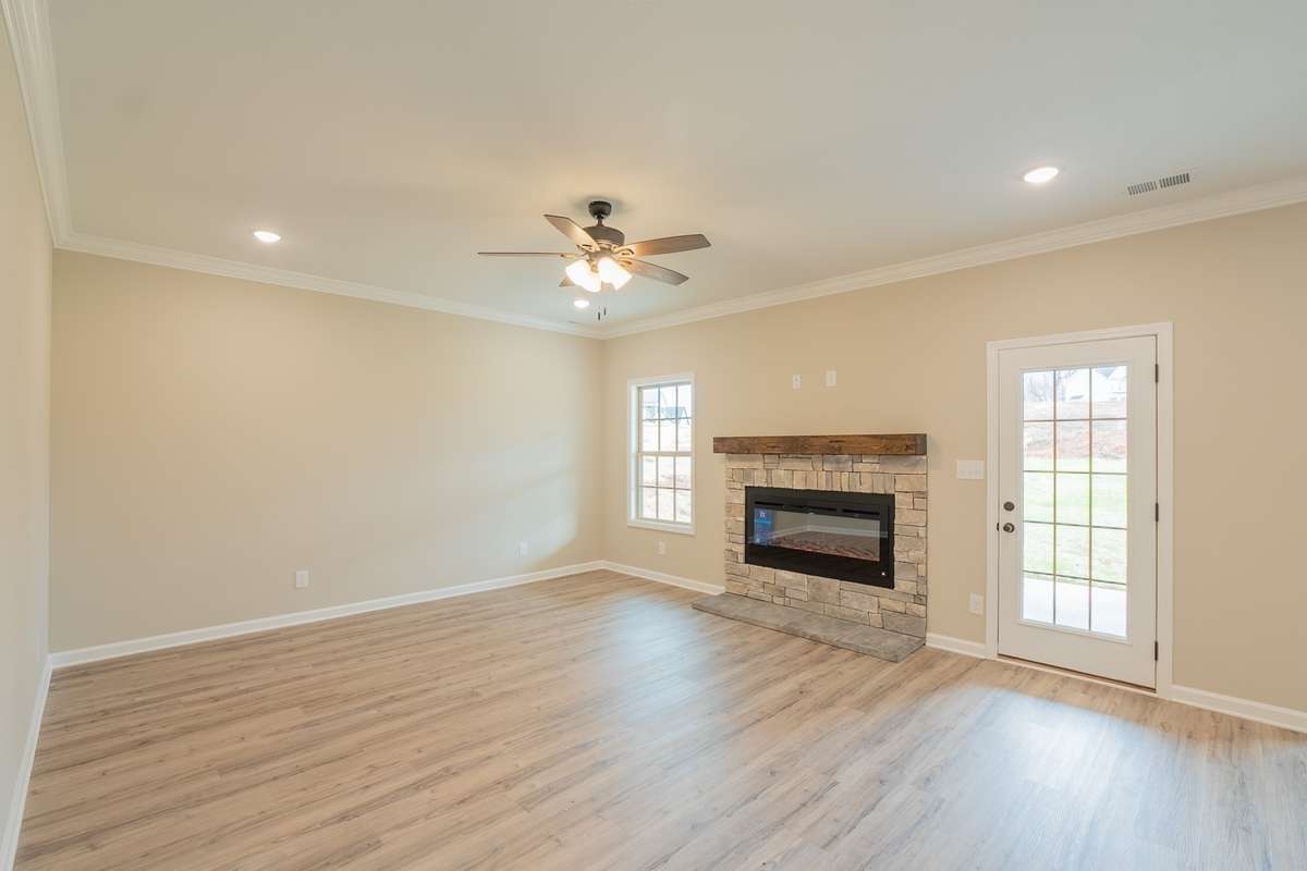EXAMPLE>>>Large Living Room with a Stone Natural Gas Fireplace, Floating Wood Mantle, Recessed Lighting, Crown Molding and Access to the Large Covered Deck!
