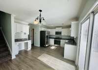 Spacious eat-in kitchen featuring granite countertops and a convenient built-in desk area, perfect for work or organization.