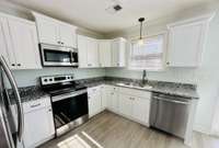 All units are equipped with upgraded stainless steel appliance packages, including a range, microwave, dishwasher, and refrigerator.