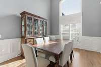 This dining room features beautiful trim and a 16' ceiling. The large windows let in lots of natural lighting.