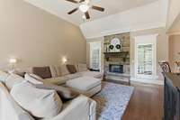 The great room features a beautiful gas stone fireplace with logs and opens to the kitchen area.