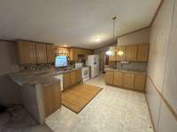 Large Eat-In Kitchen with dishwasher, stove, fridge and raised breakfast bar.