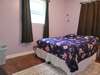 Bedroom 1 with hardwood floors and a half bath.