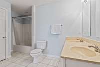 Primary bathroom features new tile flooring, neutral colored painted walls and double vanities. 