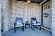 Gorgeous light brick exterior is expertly laid to create this architectural design in the covered front porch 