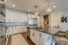 Nothing beats an inviting kitchen like this with oversized island, quartz counters & fabulous designer light pendants