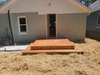 Back of home has new 10x10 picture frame platform deck with concrete sidewalk to new concrete driveway