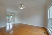 Living room with hardwood flooring, 9 foot ceiling and crown molding.