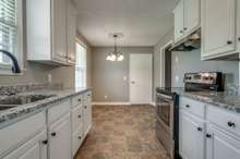 Updated galley kitchen boasts new granite countertops. 