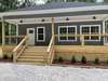 front view with new boxwoods and gravel parking area.