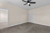 Second bedroom with neutral paint and ceiling fan