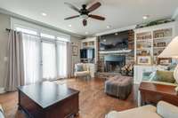 Living Room w/ Stacked Stone Gas Fireplace & Bookshelf Built Ins