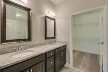 Owner's bath with double sinks and framed mirrors. Photo is NOT of actual home and finishes will vary.