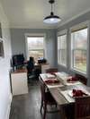 The sunroom acts as a dining room and an office for this family.