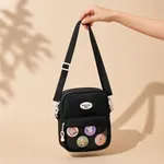 Black-nylon-crossbody-sling-bag-with-adjustable-strap-front-mesh-pocket-zip-closure-and-cartoon-badge-details
