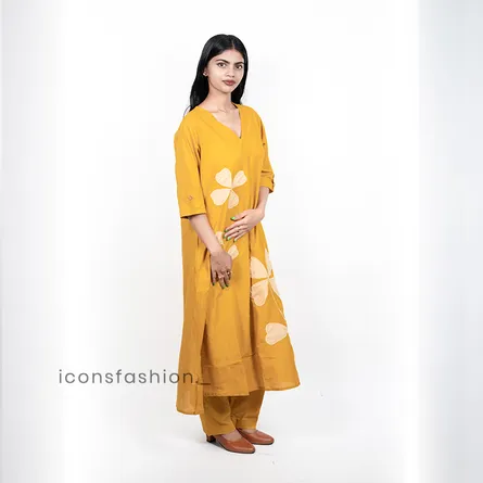 Women-wearing-a-mustard-yellow-A-line-kurta-set-with-floral-applique-work-three-quarter-sleeves-and-matching-pants