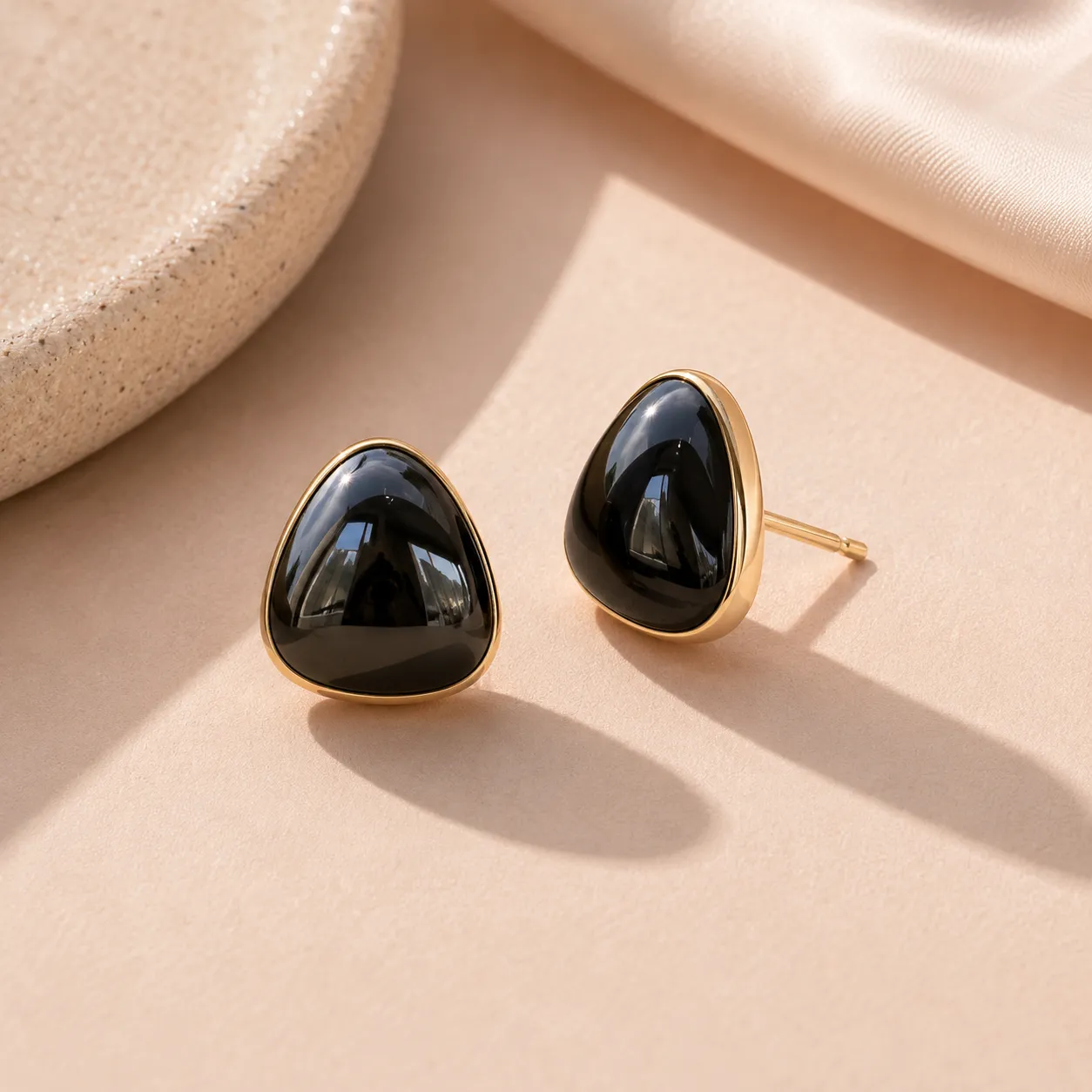 Black-teardrop-stud-earrings-with-gold-tone-border-and-glossy-finish-for-women