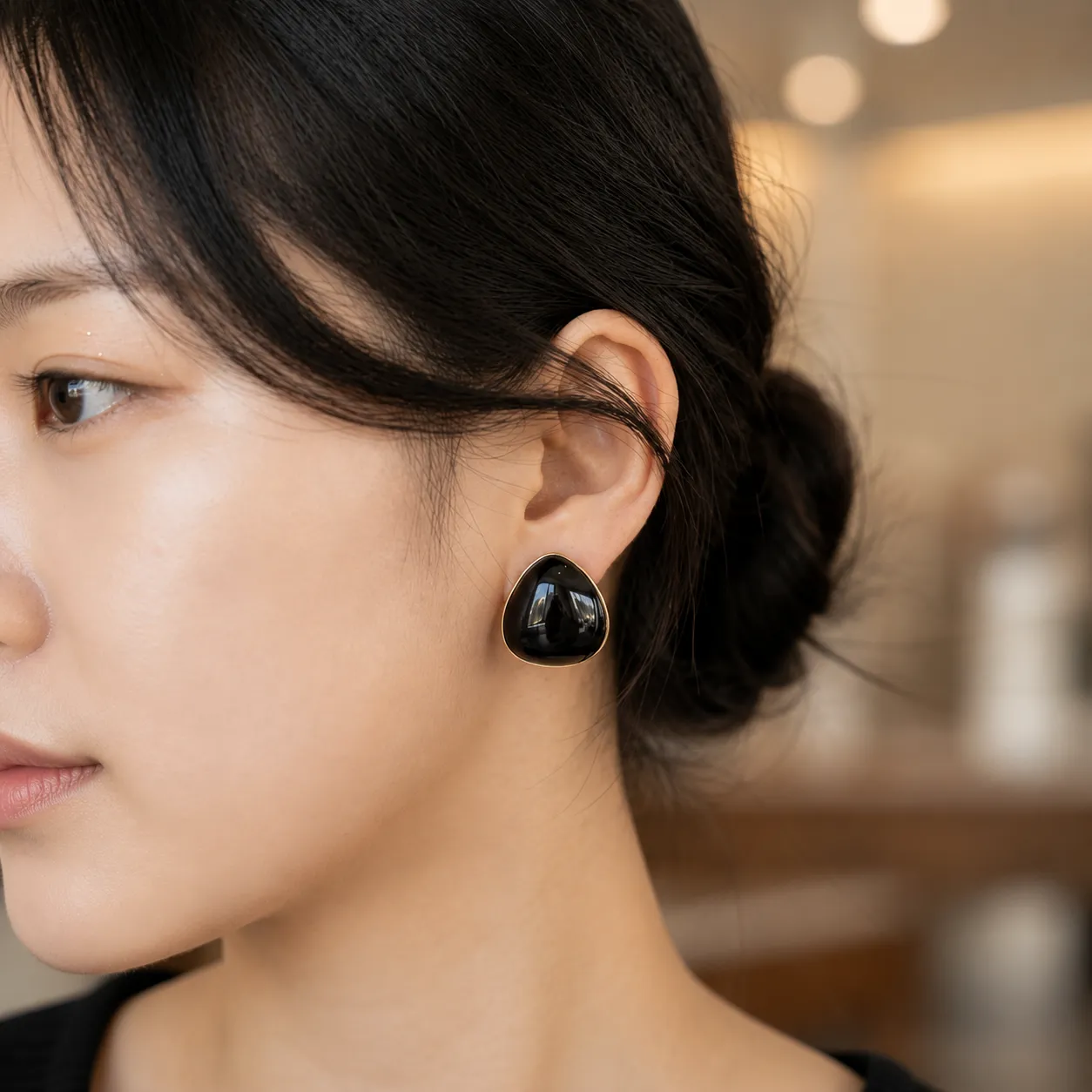 Black-teardrop-stud-earrings-with-gold-tone-border-and-glossy-finish-for-women