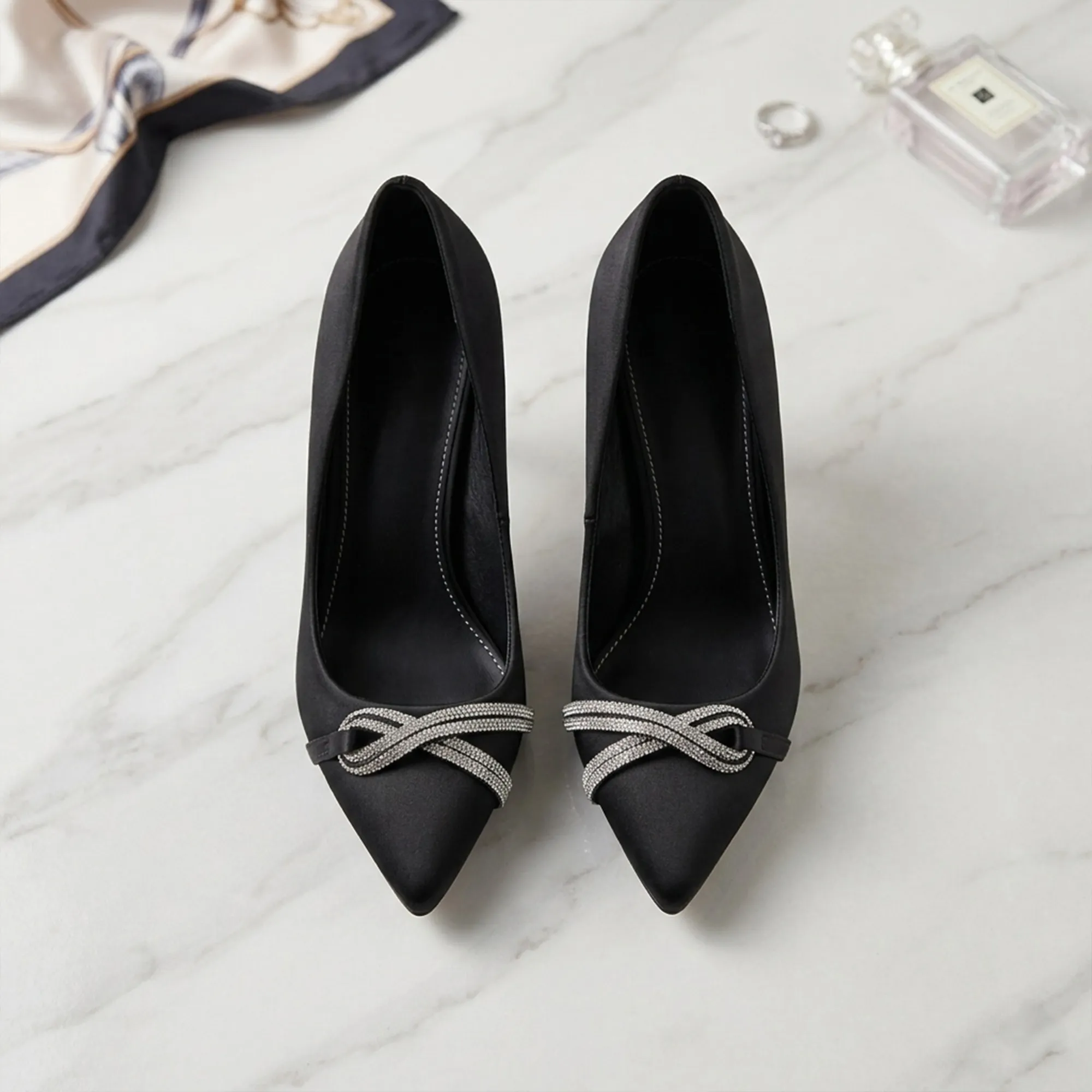 Black-satin-pointed-toe-heels-for-women-with-crystal-crossover-embellishment-and-kitten-heel-design
