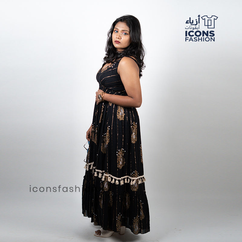 Black-sleeveless-maxi-dress-with-gold-paisley-prints-and-tassel-detailing-near-the-hem