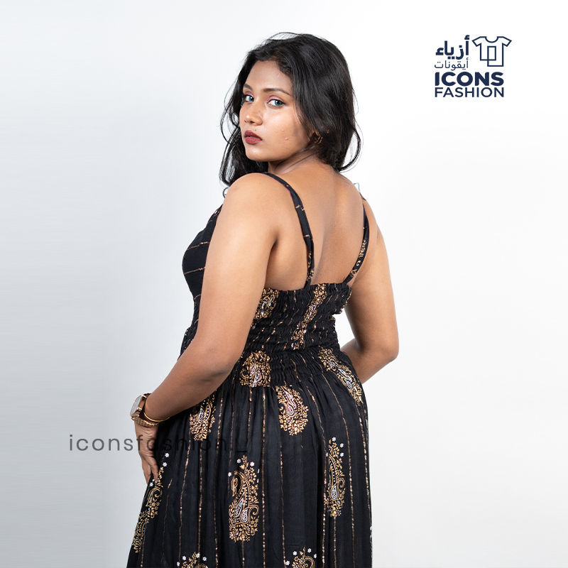 Black-sleeveless-maxi-dress-with-gold-paisley-prints-and-tassel-detailing-near-the-hem