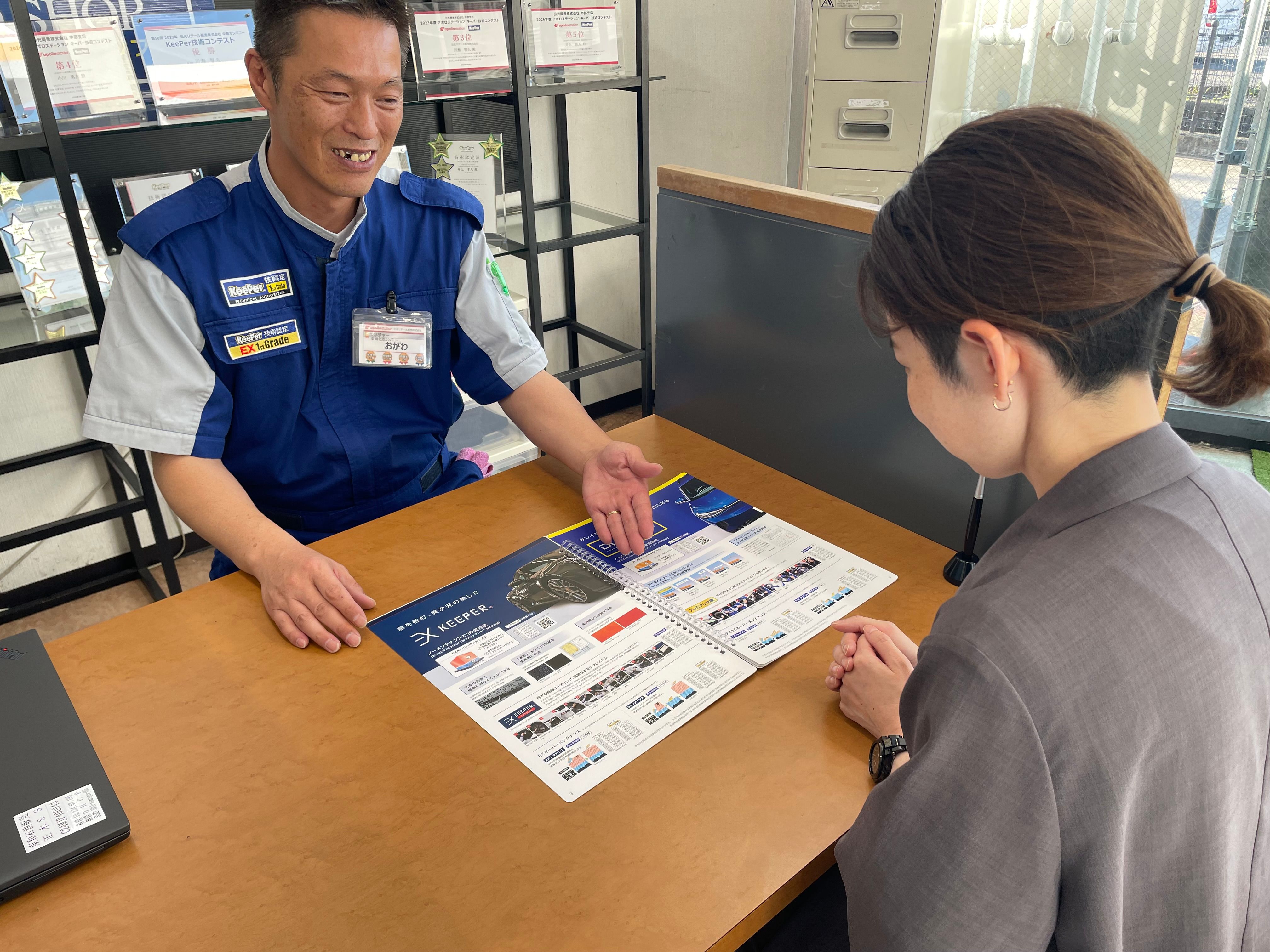 スタッフがお客様にコーティングメニューを案内している様子