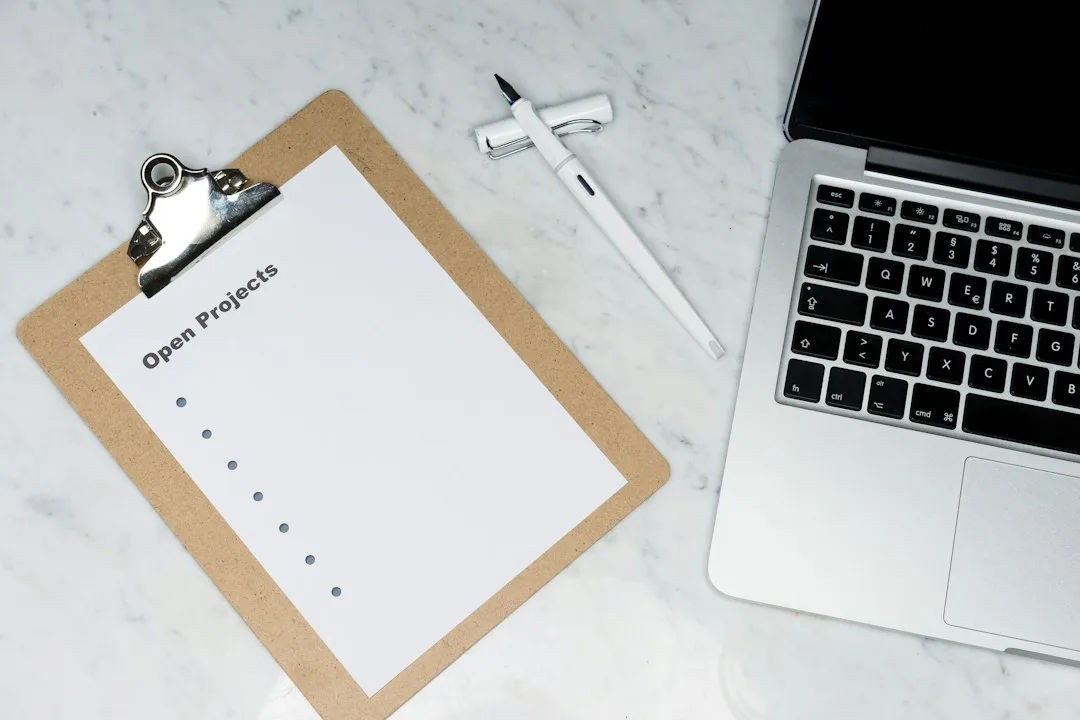 Checklist on a clipboard next to a laptop