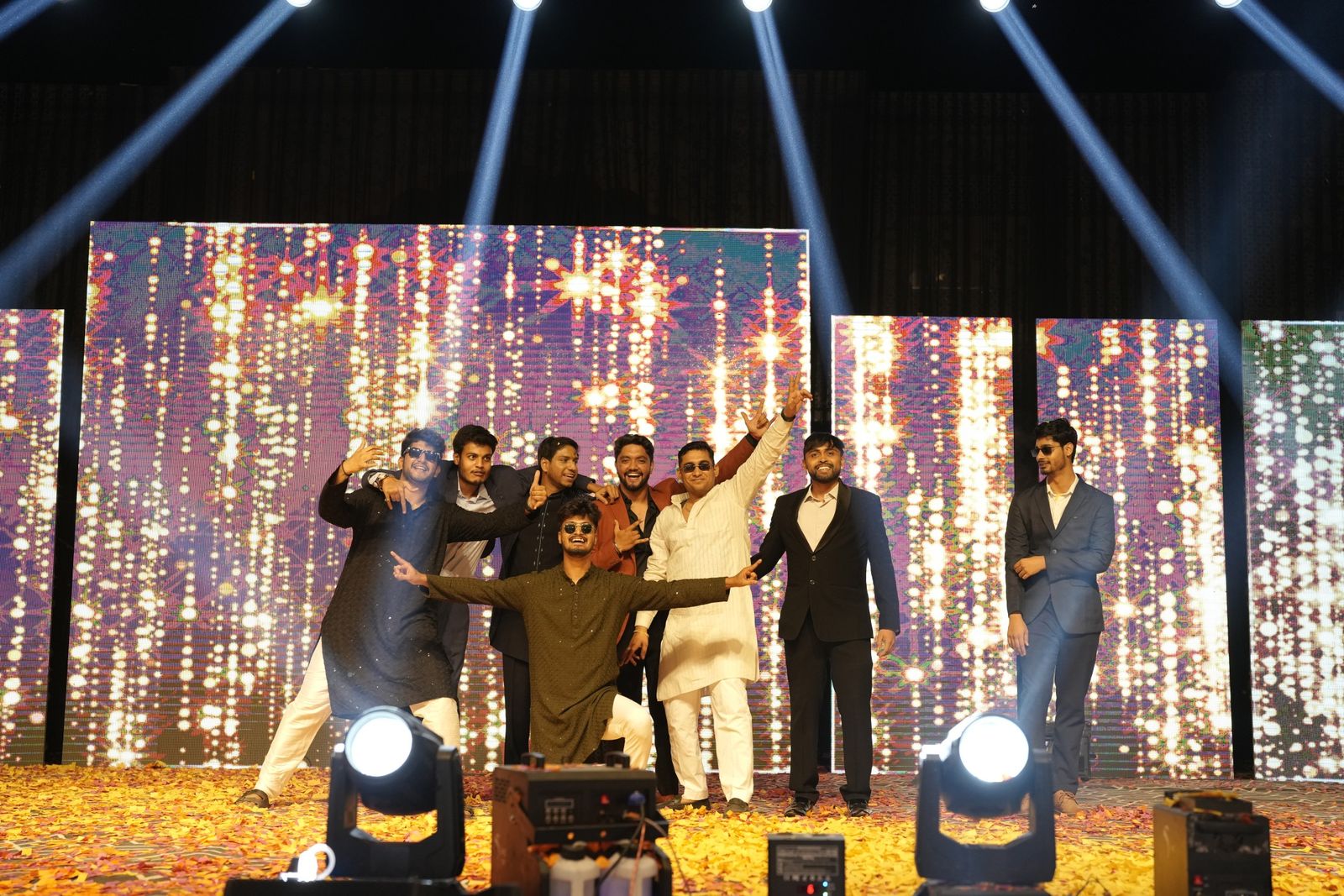 Friends performing on a lit stage at the sangeet