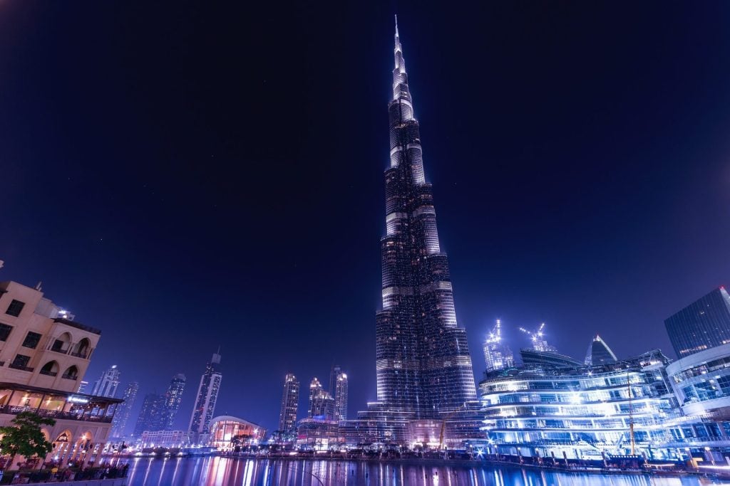 Dubai city night view with illuminated buildings and busy street with light trails
