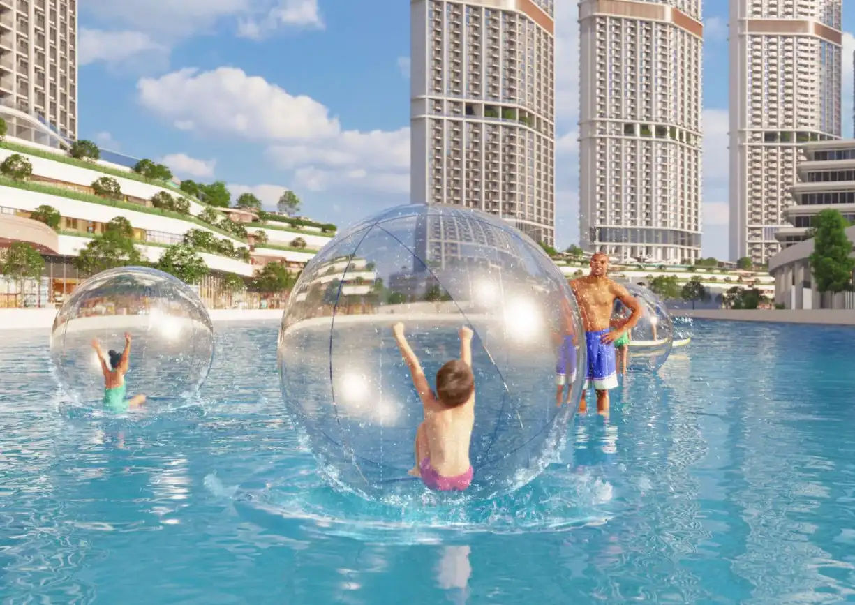 View of Yachtside Marina Residences at sunset with buildings, palm trees, and beach
