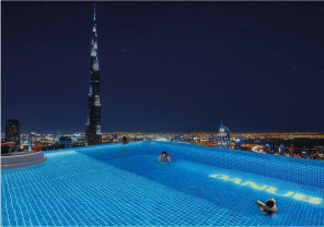 View of Yachtside Marina Residences at sunset with buildings, palm trees, and beach