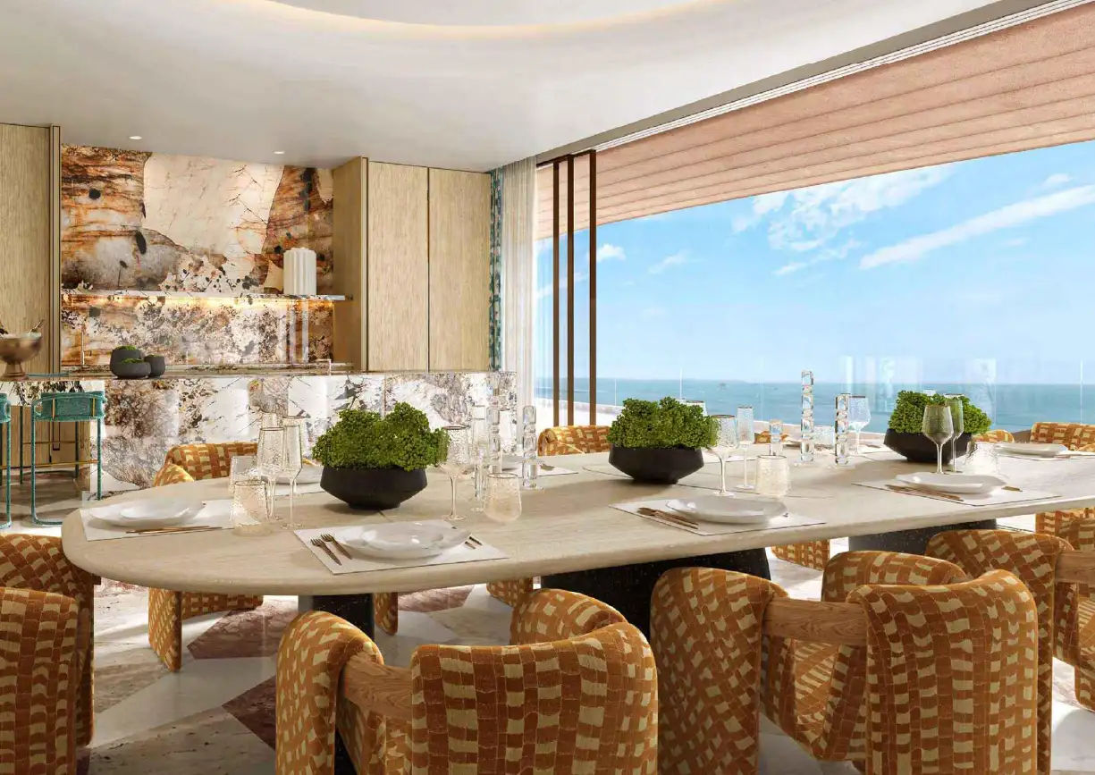 View of Yachtside Marina Residences at sunset with buildings, palm trees, and beach