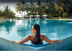 View of Yachtside Marina Residences at sunset with buildings, palm trees, and beach
