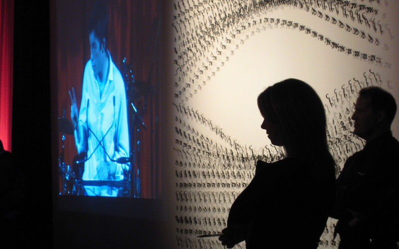 Silouette of person in front of an eye-shaped art installation