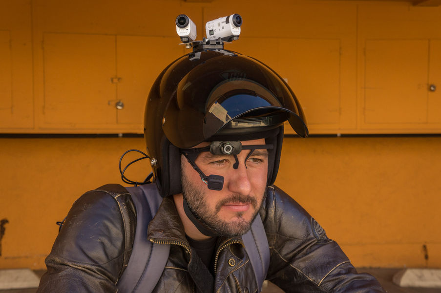 Person wearing motorcycle helmet with cameras and gaze-tracking glasses