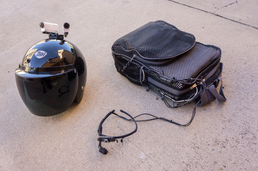 Motorcycle helmet with cameras and gaze-tracking glasses attached to backpack