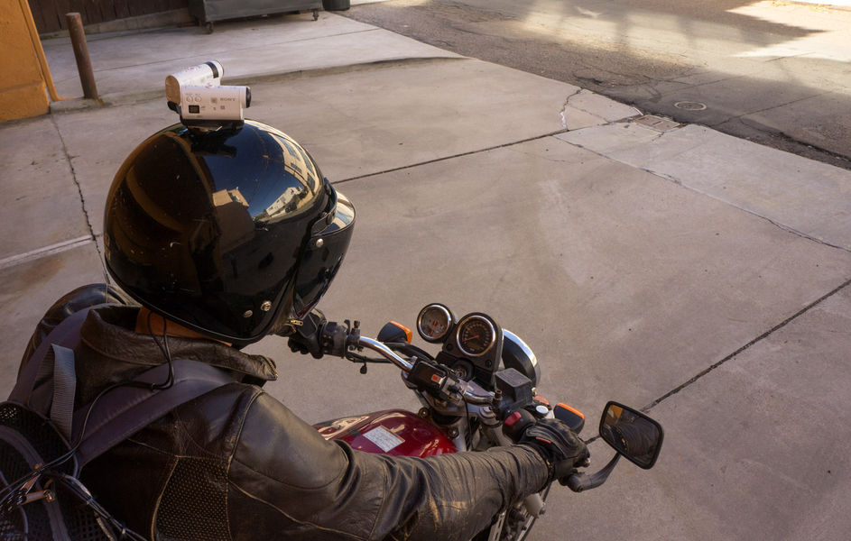 Person on a motorcycle with cameras on the helmet and trigger on the handlebars