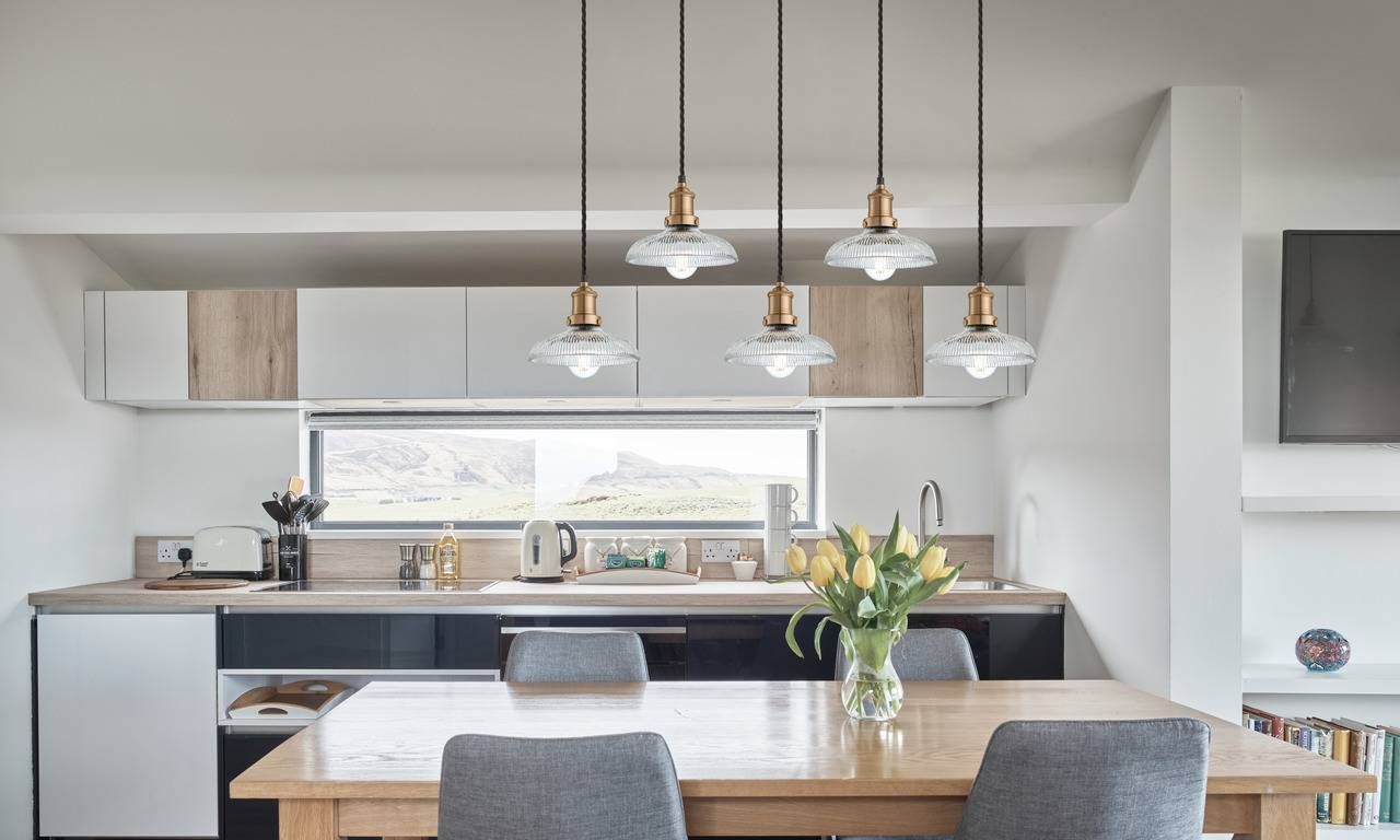 Modern style kitchen with neutral palette and 5 glass dome pendants