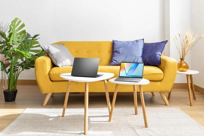 A yellow couch with two laptops on tablesAI-generated content may be incorrect.