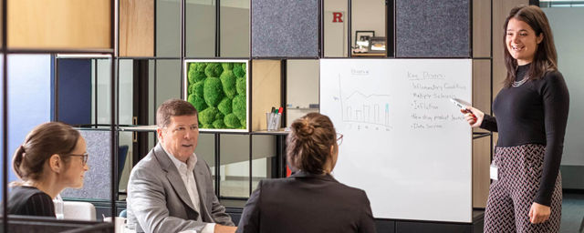 Four coworkers having a whiteboard discussion