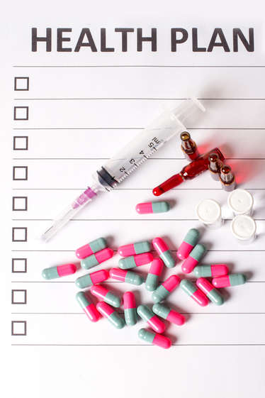 Health plan form with a syringe and capsules
