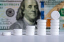 Pills stacked and money in the background