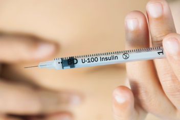 Closeup of a patient injecting insulin